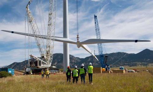 A wind turbine being erected with workers