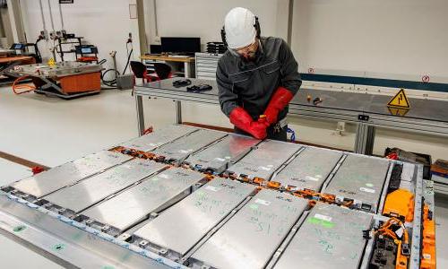 Volkswagen employee demonstrating disassembly of an electric car battery 